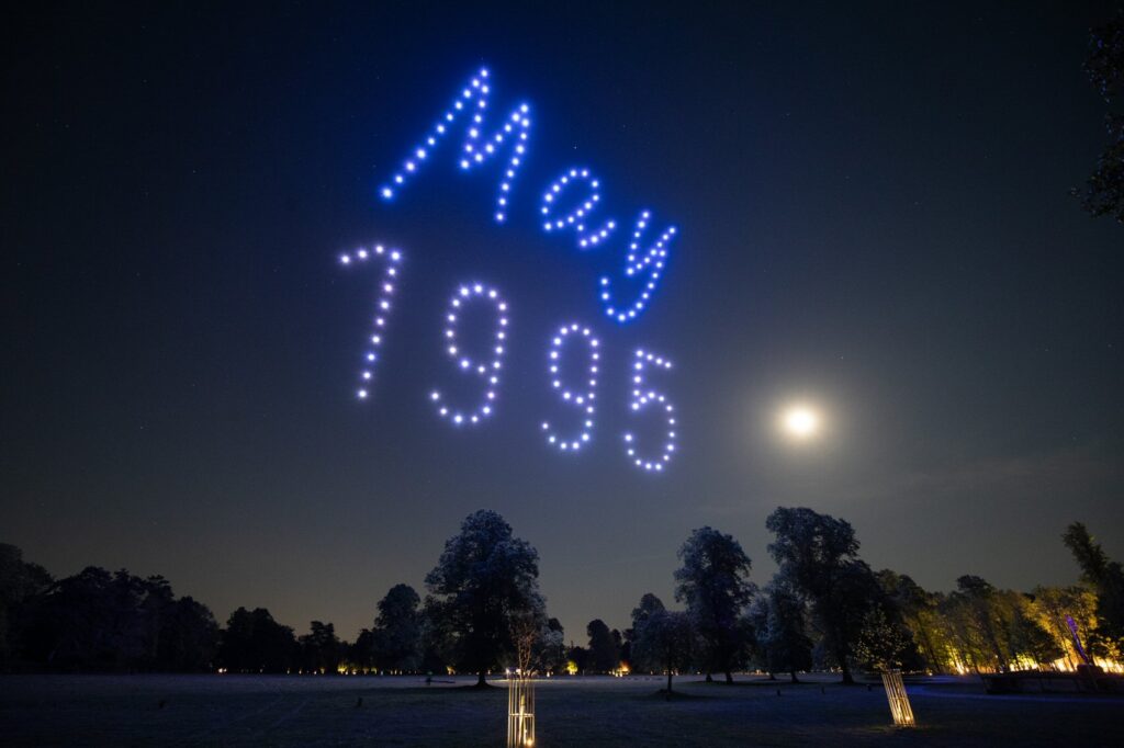 A personalised May 1995 date written in drone lights beneath the moon